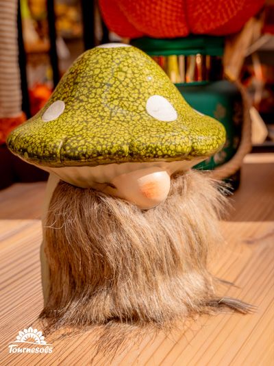 Figurine de lutin à chapeau de champignon sur une table en bois.